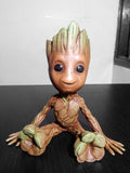 Groot baby sitting with a smile